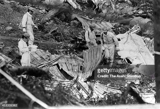 Japan Airlines staffs investigate the debris of the aft pressure bulkhead at the crash site at the ridge of Mount Osutaka on August 18, 1985 in Ueno,...