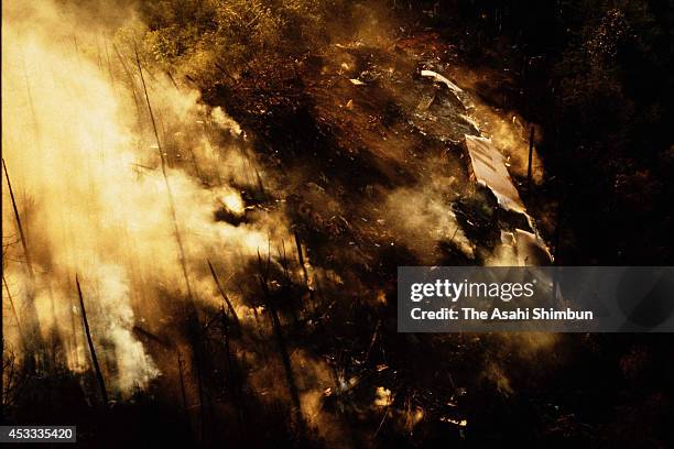 Smoke rises from the crash site at the ridge of Mount Osutaka a day after the air crash on August 13, 1985 in Ueno, Gunma, Japan. Japan Airlines...