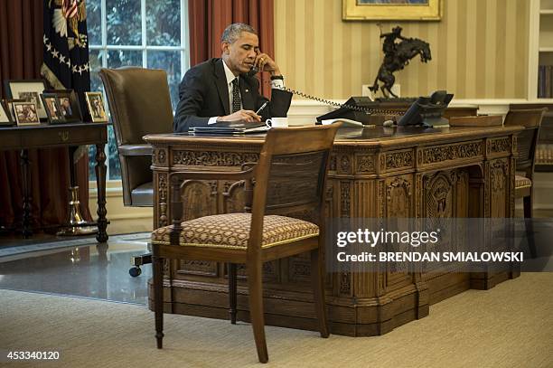 President Barack Obama speaks on the phone with King Abdullah II of Jordan in the Oval Office of the White House on August 8, 2014 in Washington, DC....