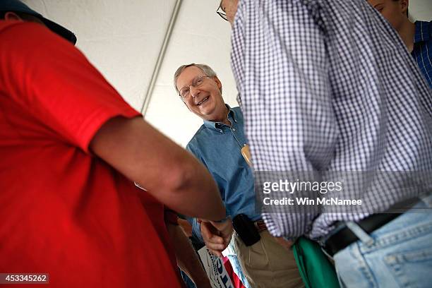 Senate Minority Leader Mitch McConnell greets supporters while at a campaign rally beneath a small tent outside the Double Kwik Marathon Gas station...