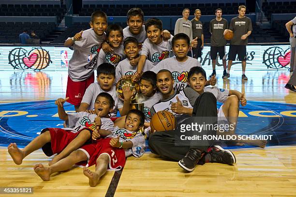 Patty Mills of San Antonio Spurs poses for a picture with Triquis native boys at the Arena Ciudad de Mexico, in Mexico City, on December 3, 2013....
