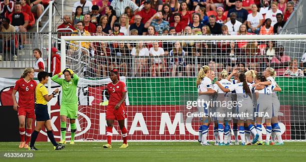 Finland players celebrate their opening goal scored by Juliette Kemppi as Canada goalkeeper Kailen Sheridan holds her head in her hands during the...