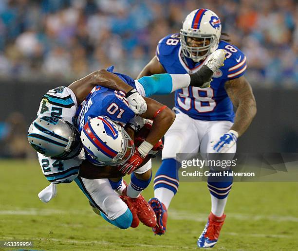Josh Norman of the Carolina Panthers tackles Robert Woods of the Buffalo Bills during their game at Bank of America Stadium on August 8, 2014 in...