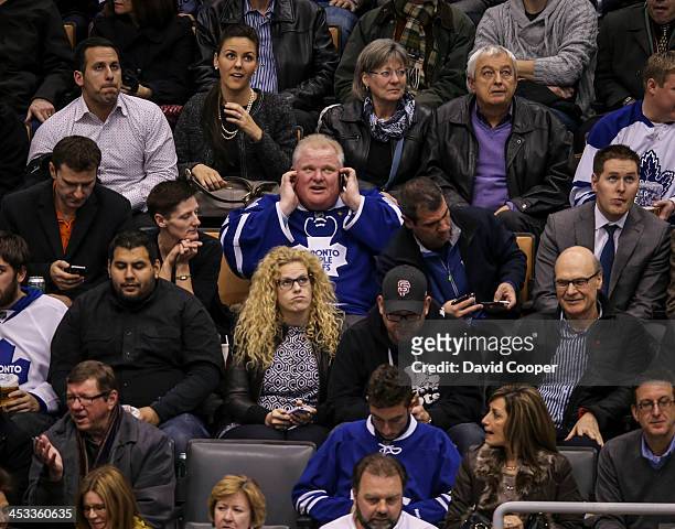 Mayor Rob Ford talks on his cell phone as he sitting in the seats behind the San Jose Sharks bench the 3rd period as the Toronto Maple Leafs take on...