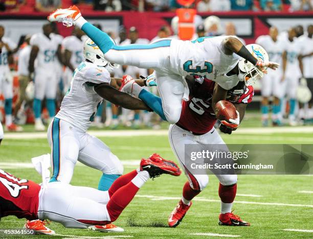 Marcus Thigpen of the Miami Dolphins is upended on a run by Kimario McFadden of the Atlanta Falcons in the fourth quarter of a preseason game at the...