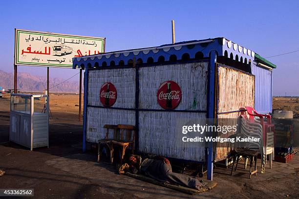 Egypt, Sinai Peninsula, Nuweiba, Street Scene, Man Sleeping In Front Of Kiosk.