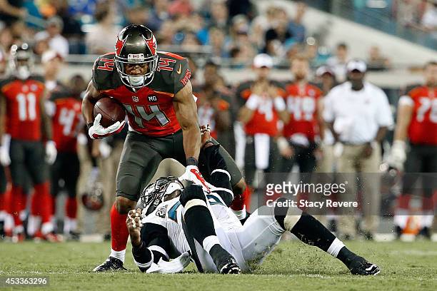 Robert Herron of the Tampa Bay Buccaneers avoids a tackle by Sherrod Martin of the Jacksonville Jaguars during a preseason game at EverBank Field on...