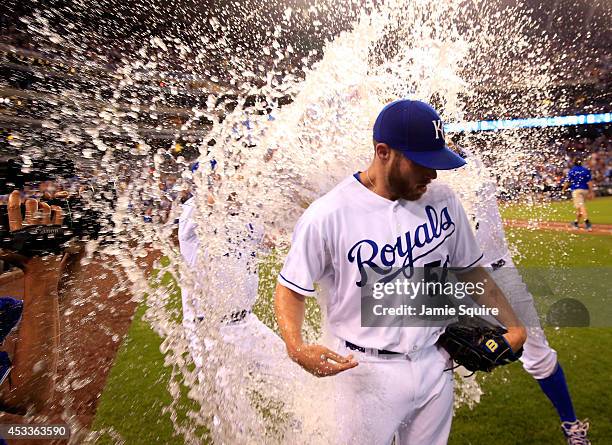 Closer Greg Holland of the Kansas City Royals is doused with water by Danny Duffy and Salvador Perez after recording his 100th career save as the...