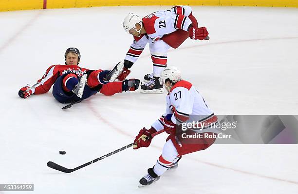 Aaron Volpatti of the Washington Capitals and Manny Malhotra of the Carolina Hurricanes get tangled up as Justin Faulk of the Carolina Hurricanes...