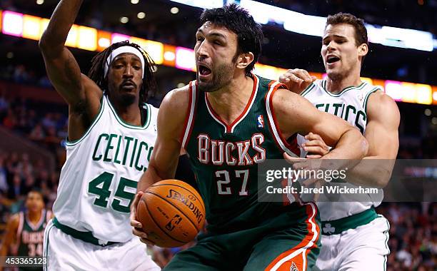Zaza Pachulia of the Milwaukee Bucks is defneded underneath the basket by Gerald Wallace and Kris Humphries of the Boston Celtics in the second half...