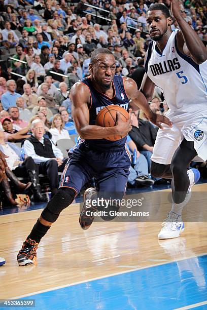 Kemba Walker of the Charlotte Bobcats drives against Bernard James of the Dallas Mavericks on December 3, 2013 at the American Airlines Center in...