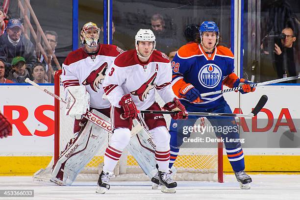 Ryan Jones of the Edmonton Oilers looks for an opportunity as Keith Yandle and Mike Smith of the Phoenix Coyotes defend net during an NHL game at...