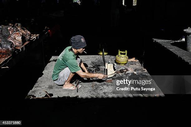 Man roasts a bat at Langowan traditional market on August 9, 2014 in Langowan, North Sulawesi. The Langowan traditional market is famous for selling...