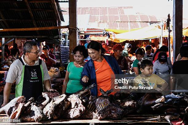 Consumers look at wild boar meat at Langowan traditional market on August 9, 2014 in Langowan, North Sulawesi. The Langowan traditional market is...