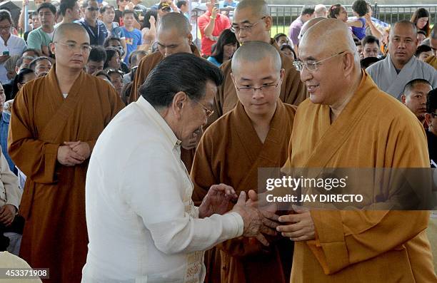 Former Philippine president and now Manila Mayor Joseph Estrada greets Chinese Buddhist monks before they perform rites for a day of special prayers...