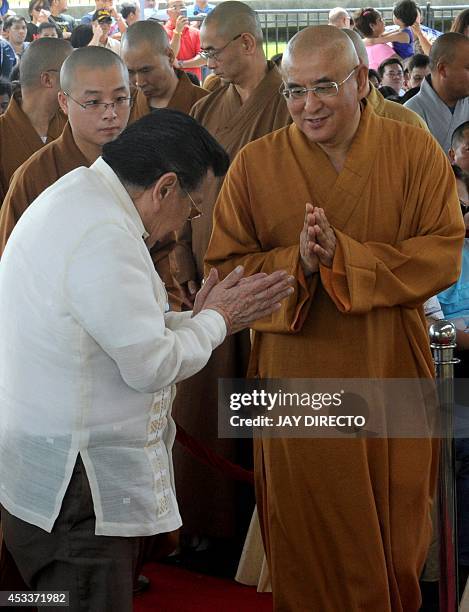 Former Philippine president and now Manila Mayor Joseph Estrada greets Chinese Buddhist monks before they perform rites for a day of special prayers...