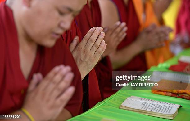 Chinese Buddhist monks pray during a day of special prayers at the Quirino Grandstand in Manila on August 9 in memory of the victims of a...