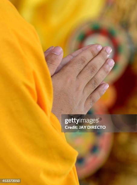 Chinese Buddhist monk prays during a day of special prayers at the Quirino Grandstand in Manila on August 9 in memory of the victims of a...