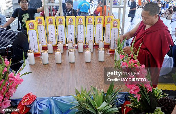 Chinese Buddhist monk performs rites for a day of special prayers at the Quirino Grandstand in Manila on August 9 in memory of the victims of a...