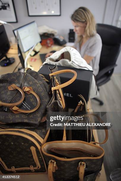 An employee of Instant Luxe registers and puts offers online for pre-owned Luxury bags at Instant Luxe office on July 30, 2014 in Paris. Instant Luxe...
