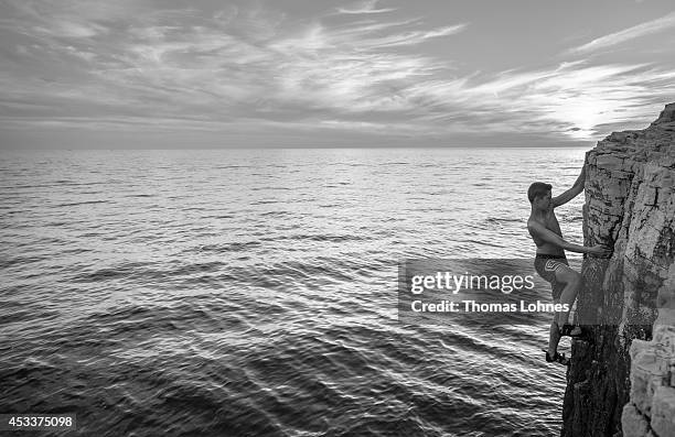 Climber walks over a 'Slackline' at the cliffs of Stoja on August 8, 2014 near Pula, Croatia. 'Deep Water Soloing' , free climbing over water, is a...