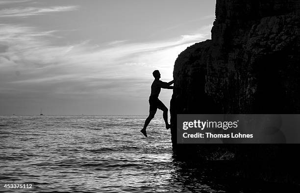 Climber walks over a 'Slackline' at the cliffs of Stoja on August 8, 2014 near Pula, Croatia. 'Deep Water Soloing' , free climbing over water, is a...