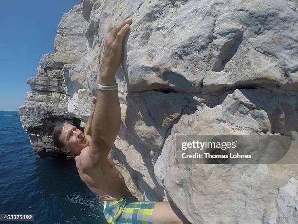 Climber walks over a 'Slackline' at the cliffs of Stoja on August 8, 2014 near Pula, Croatia. 'Deep Water Soloing' , free climbing over water, is a...