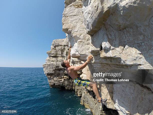 Climber walks over a 'Slackline' at the cliffs of Stoja on August 8, 2014 near Pula, Croatia. 'Deep Water Soloing' , free climbing over water, is a...