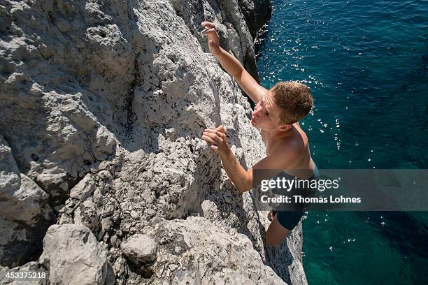 Climber walks over a 'Slackline' at the cliffs of Stoja on August 8, 2014 near Pula, Croatia. 'Deep Water Soloing' , free climbing over water, is a...