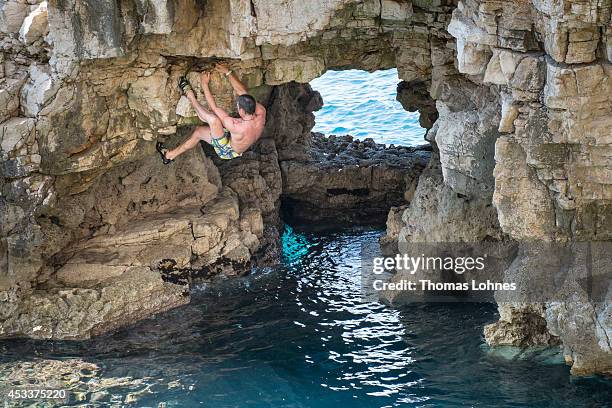 Climber walks over a 'Slackline' at the cliffs of Stoja on August 8, 2014 near Pula, Croatia. 'Deep Water Soloing' , free climbing over water, is a...