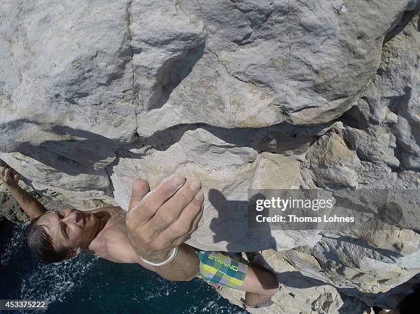 Climber walks over a 'Slackline' at the cliffs of Stoja on August 8, 2014 near Pula, Croatia. 'Deep Water Soloing' , free climbing over water, is a...