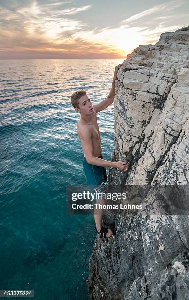 Climber walks over a 'Slackline' at the cliffs of Stoja on August 8, 2014 near Pula, Croatia. 'Deep Water Soloing' , free climbing over water, is a...