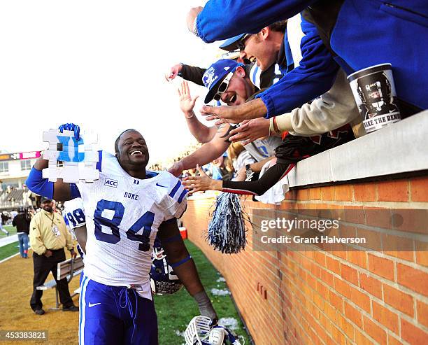 Kenny Anunike of the Duke Blue Devils celebrates with fans after a win over the Wake Forest Demon Deacons at BB&T Field on November 23, 2013 in...