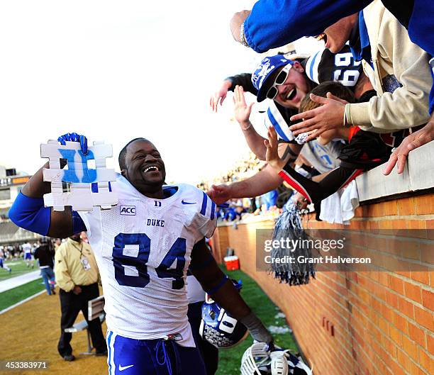 Kenny Anunike of the Duke Blue Devils celebrates with fans after a win over the Wake Forest Demon Deacons at BB&T Field on November 23, 2013 in...