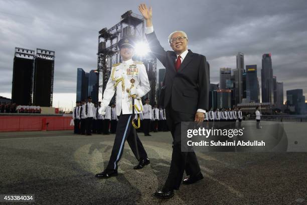 President of Singapore, Tony Tan Keng Yam waves to the audience after inspecting the guard of honour contingent during the National Day Parade at the...