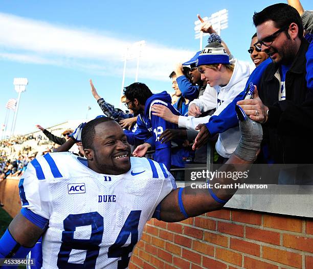 Kenny Anunike of the Duke Blue Devils celebrates with fans after a win over the Wake Forest Demon Deacons at BB&T Field on November 23, 2013 in...