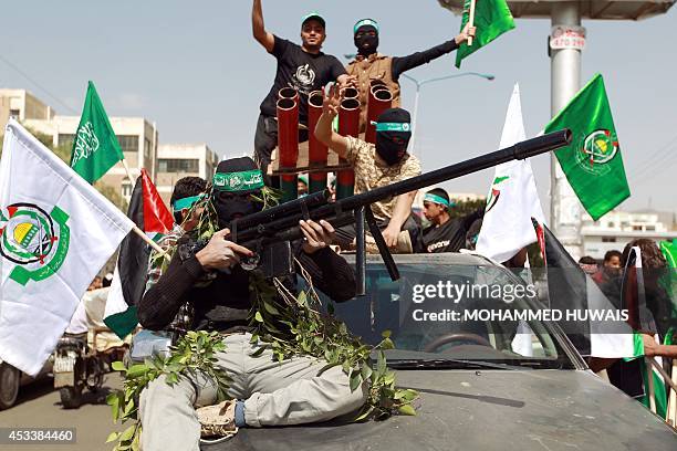 Yemeni protesters hold flags of the Palestinian Islamic movement Hamas next to a mock rocket launch pad mounted on a car during a demonstration in...