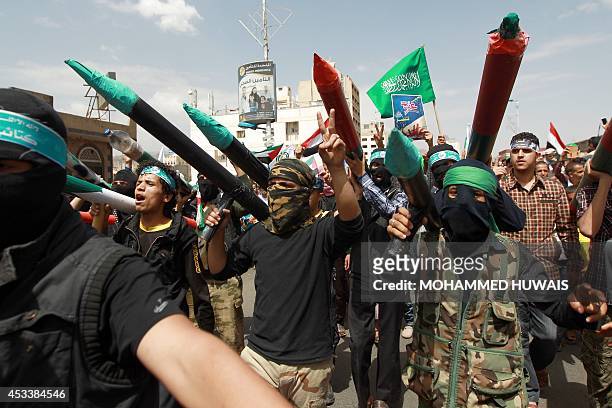 Yemeni protesters carry mock Qassam rockets shouting slogans during a demonstration in solidarity with Palestinians in the Gaza Strip, on August 9 in...