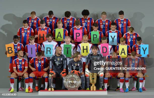 The members of German first division Bundesliga football club FC Bayern Munich hold up cardboards with letters of the word "Happy Birthday" during a...
