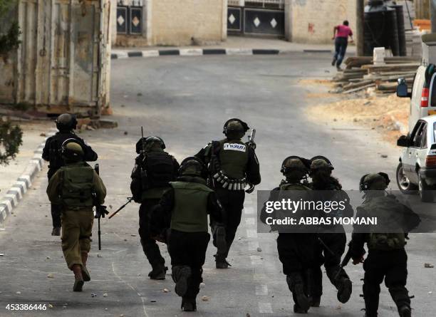 Israeli soldiers clash with Palestinian demonstrators at the entrance of the Jewish settlement of Psagot near the Palestinian town of Al-Bireh on...