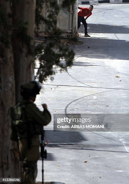 An Israeli soldier holds his position during clashes with Palestinian demonstrators at the entrance of the Jewish settlement of Psagot near the...