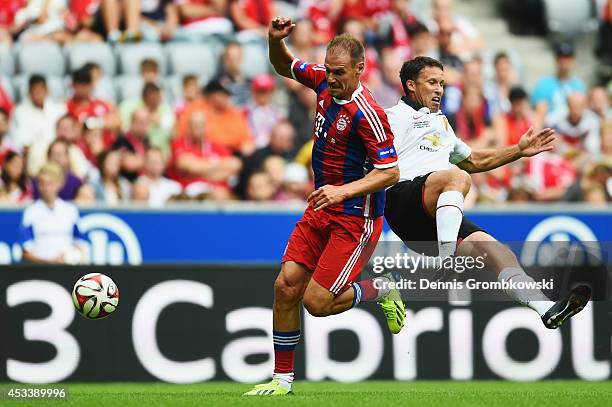 Alexander Zickler of FCB AllStars is challenged by Ronny Johnsen of ManUtd Legends during the friendly match between FC Bayern Muenchen AllStars and...