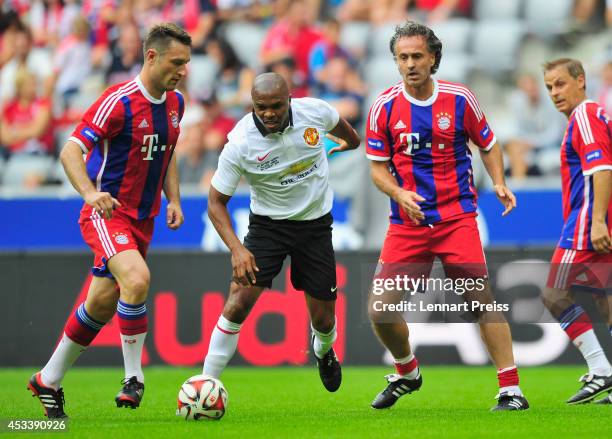 Robert Kovac and Maurizio Gaudino of FCB AllStars challenge Quinton Fortune of ManUtd Legends during the friendly match between FC Bayern Muenchen...