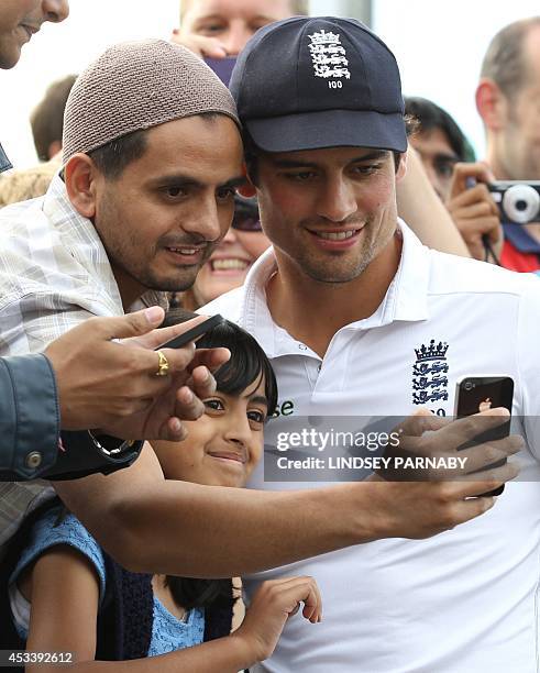 England captain Alastair Cook poses for photographs with fans after defeating India in the fourth cricket Test match between England and India at Old...