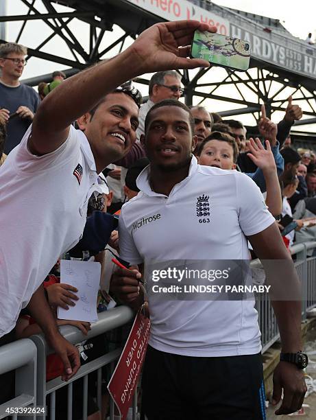 England's Chris Jordan poses for photographs with fans after defeating India in the fourth cricket Test match between England and India at Old...