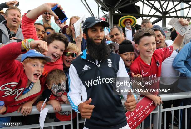 England's Moeen Ali poses for photographs with fans after defeating India in the fourth cricket Test match between England and India at Old Trafford...