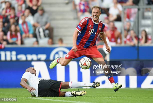 Alexander Zickler of Muenchen and Dion Dublin of Manchester compete for the ball during the friendly match between FC Bayern Muenchen Allstars and...