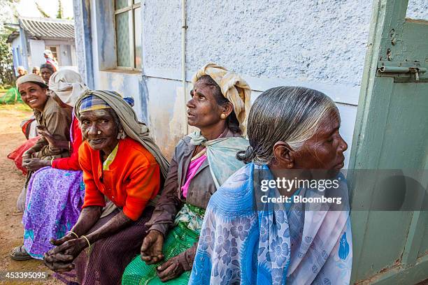 Workers wait for payment as the bags of tea leaves that they picked are weighed at a Santosh Tea Industries Pvt. Collection center in Coonoor, Tamil...