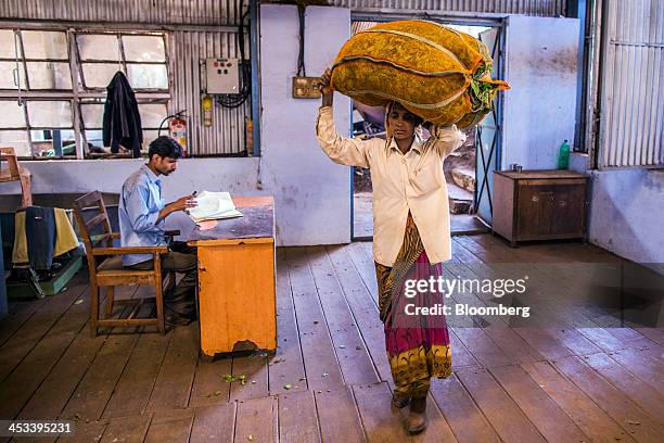 Worker carries a bag of tea leaves into the Highfield Tea Estate factory in Coonoor, Tamil Nadu, India, on Saturday, Nov. 30, 2013. India is the...