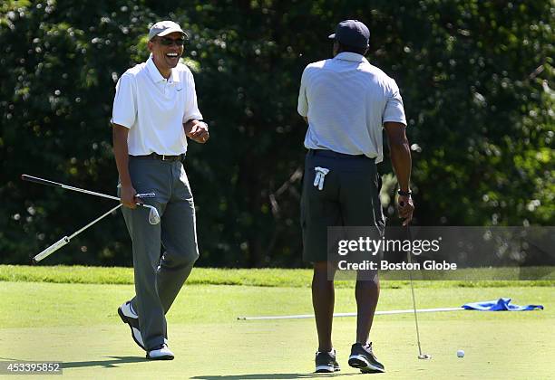 President Barack Obama, left, is all smiles as he approaches one of his golfing partners Ahmad Rashad, right, the former NFL player, while golfing at...